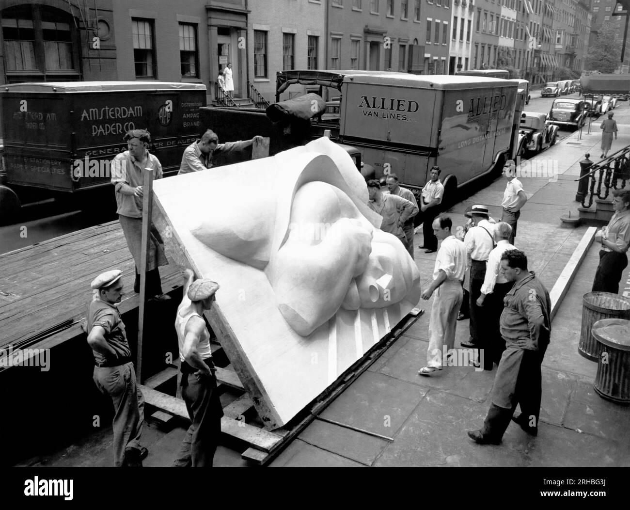 New York, New York : 1940 Isamu Noguchi regardant une partie de la plaque de bâtiment Associated Press, qui a été sculptée dans le plâtre et coulée en acier inoxydable - à l'époque la plus grande coulée en acier inoxydable jamais réalisée. Il est toujours installé au Rockefeller Center. Banque D'Images