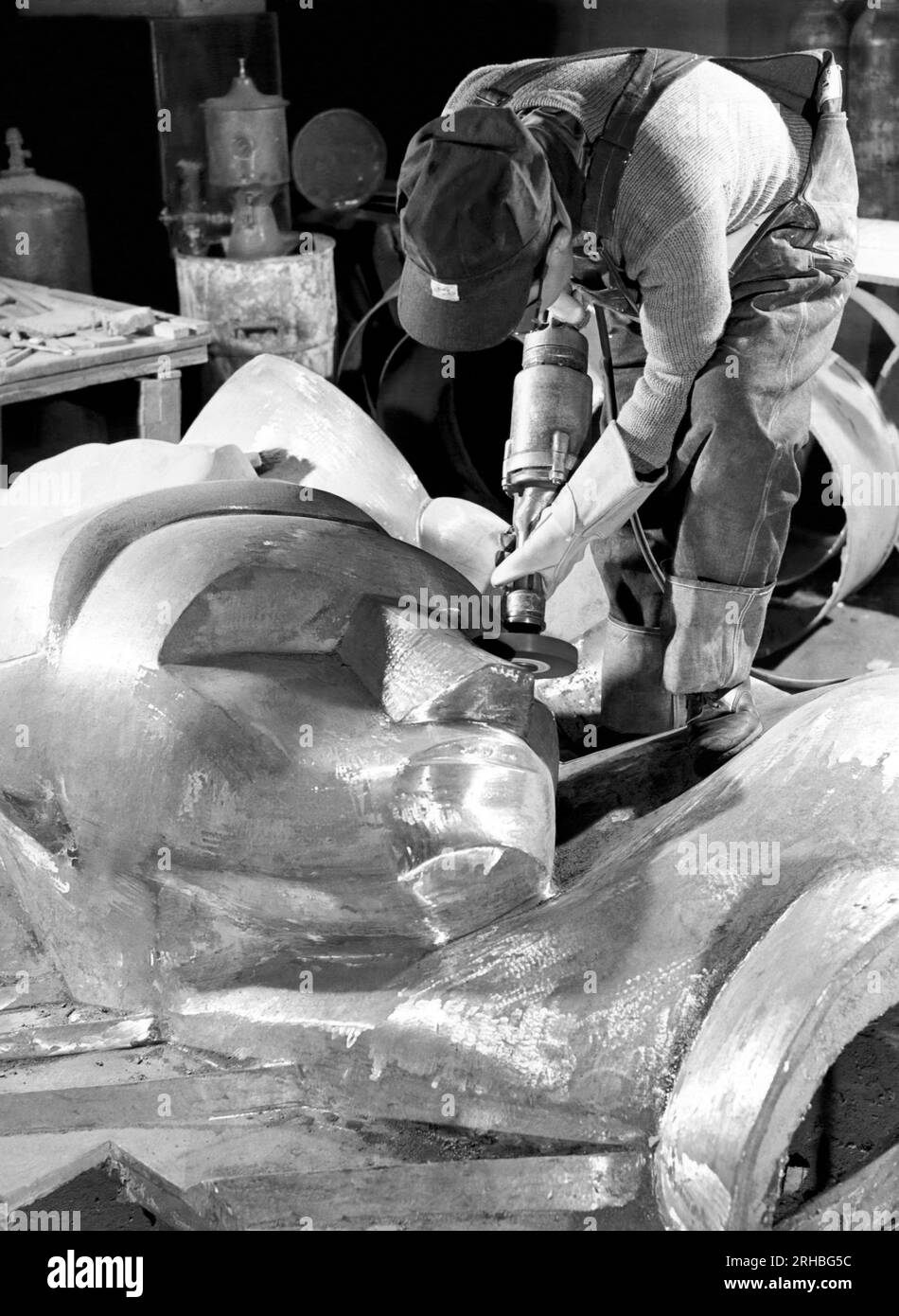 New York, New York : 1940 Isamu Noguchi travaille sur l'Associated Press Building plaque, qui a été sculptée dans le plâtre et coulée en acier inoxydable - à l'époque la plus grande coulée d'acier inoxydable jamais réalisée. Il est toujours installé au Rockefeller Center. Banque D'Images