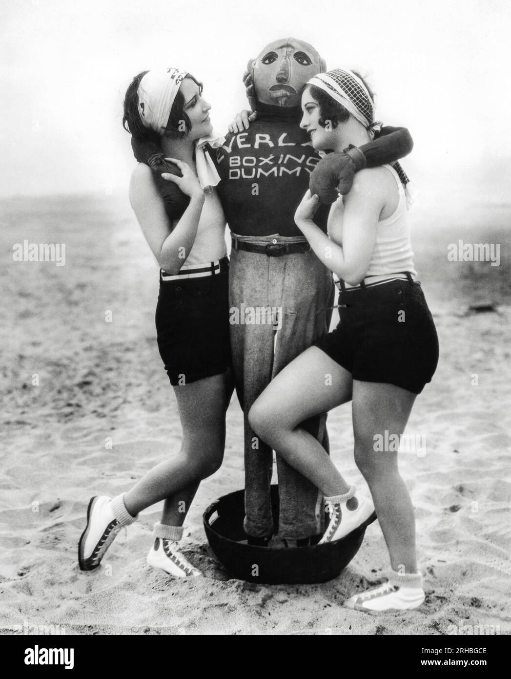 Hollywood, Californie : 21 juin 1927 les actrices Dorothy Sebastian (à gauche) et Joan Crawford (à droite) se disputent l'affection d'un mannequin de boxe Everlast. Banque D'Images