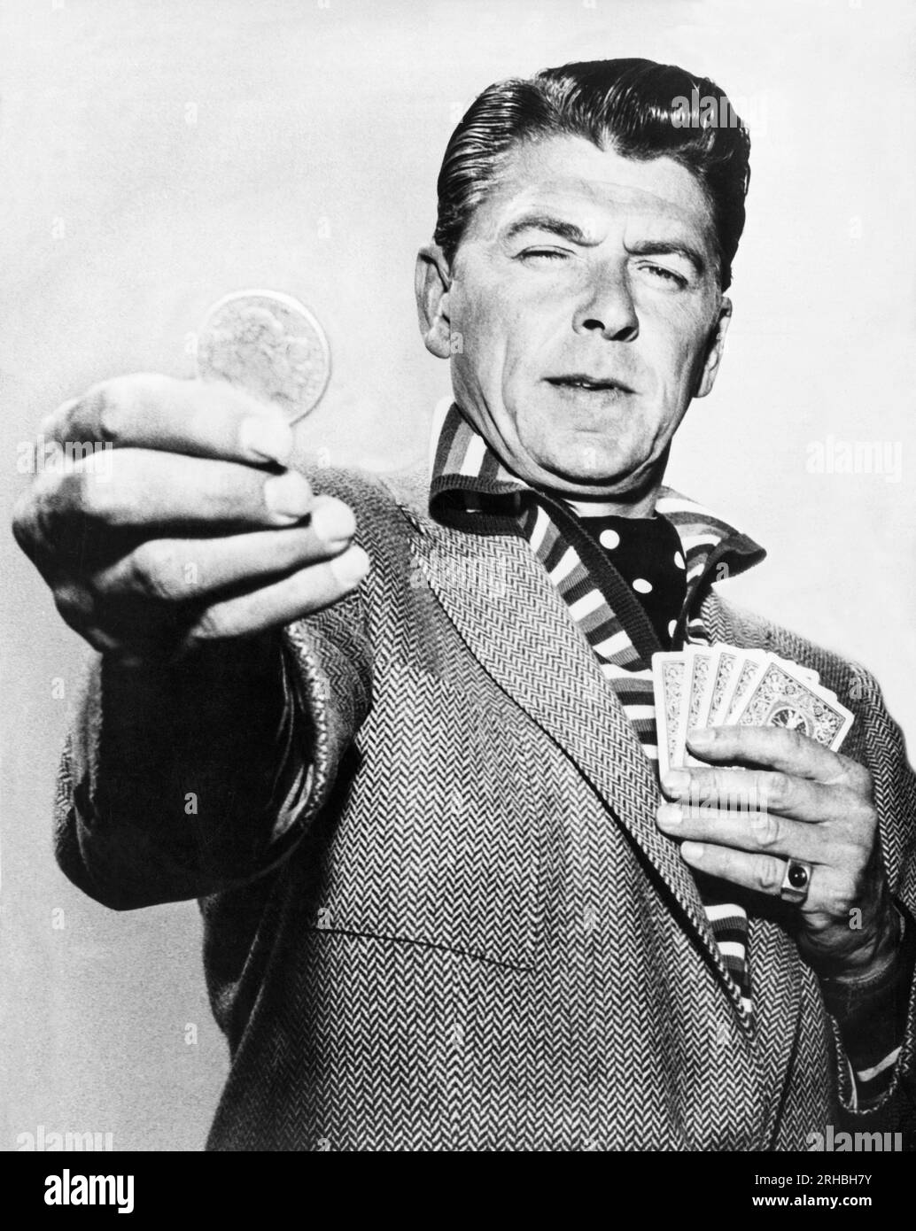 New York, New York : avril 1958 l'acteur Ronald Reagan jette un long regard sur une pièce d'argent dans le téléplay CBS du General Electric Theater, 'The Lord's Dollar'. Banque D'Images