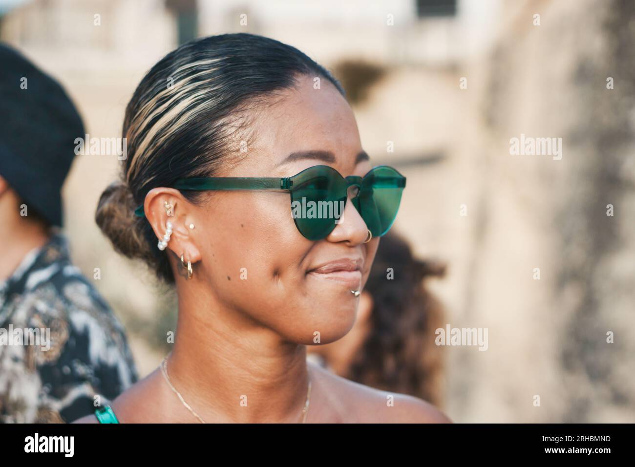 Gros plan portrait d'une jeune femme japonaise bronzée portant des lunettes de soleil teintées vertes sans monture Banque D'Images