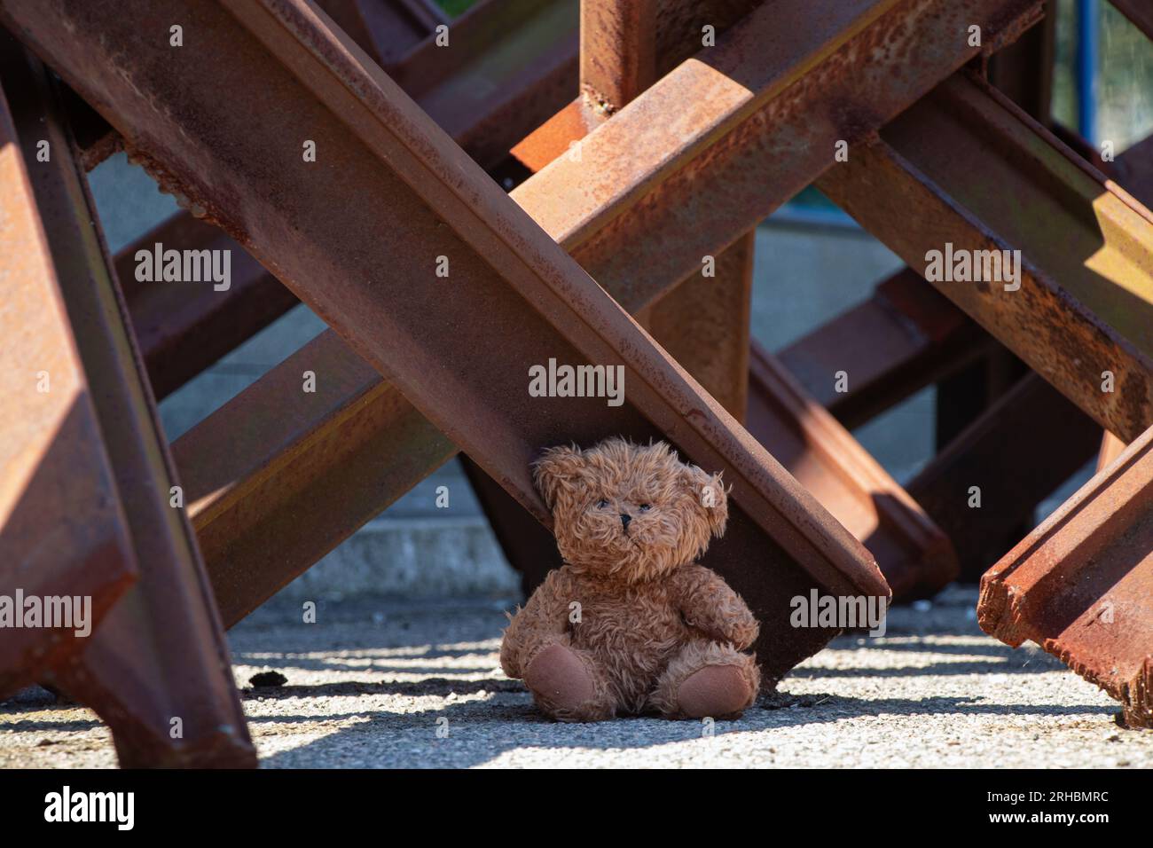 Un ours en peluche se trouve à côté d'un hérisson antichar sur une route dans la ville de Dnipro en Ukraine pendant la guerre Banque D'Images