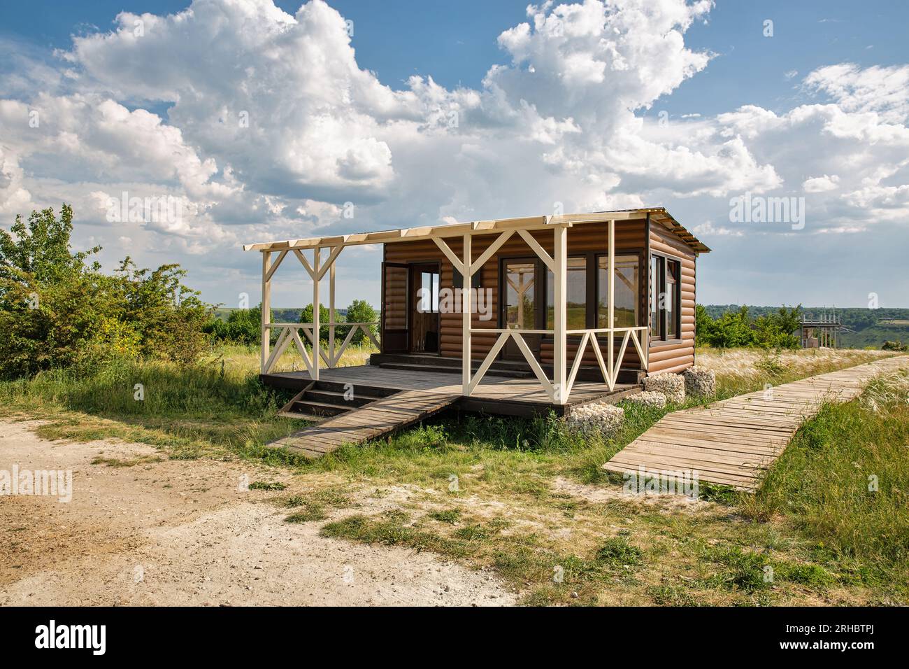 Petite maison moderne en bois dans un champ clair wirh boardwalk en bois Banque D'Images