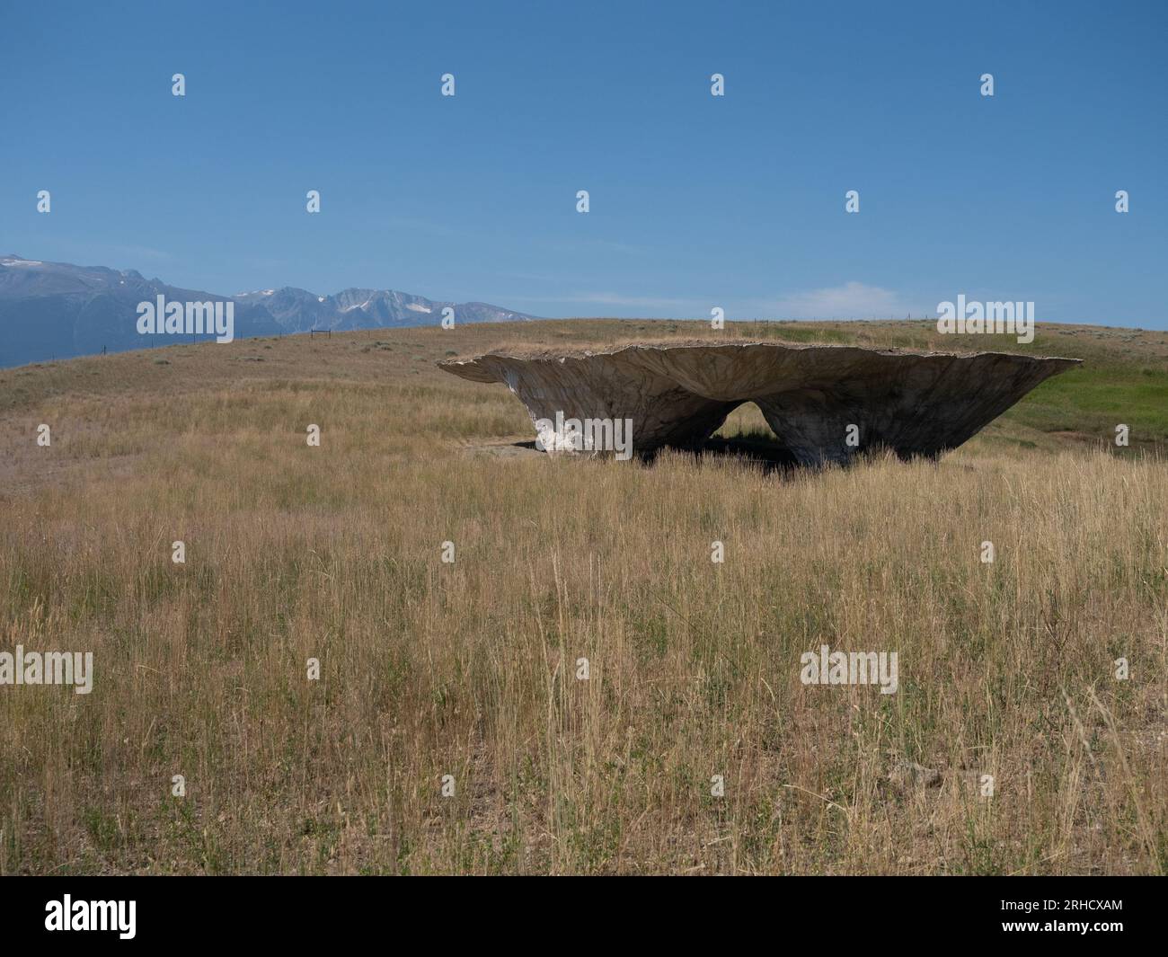 Le Domo au Tippet Rise Art Center près de Fishtail, Montana, avec un champ d'herbe séchée au premier plan et les montagnes Beartooth en arrière-plan Banque D'Images
