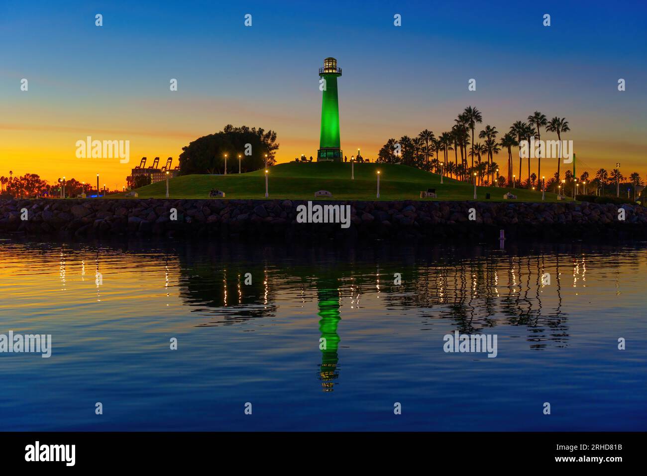 Aire de loisirs autour du phare du Lion à long Beach, illuminée par une lumière verte, vue de l'eau. Banque D'Images