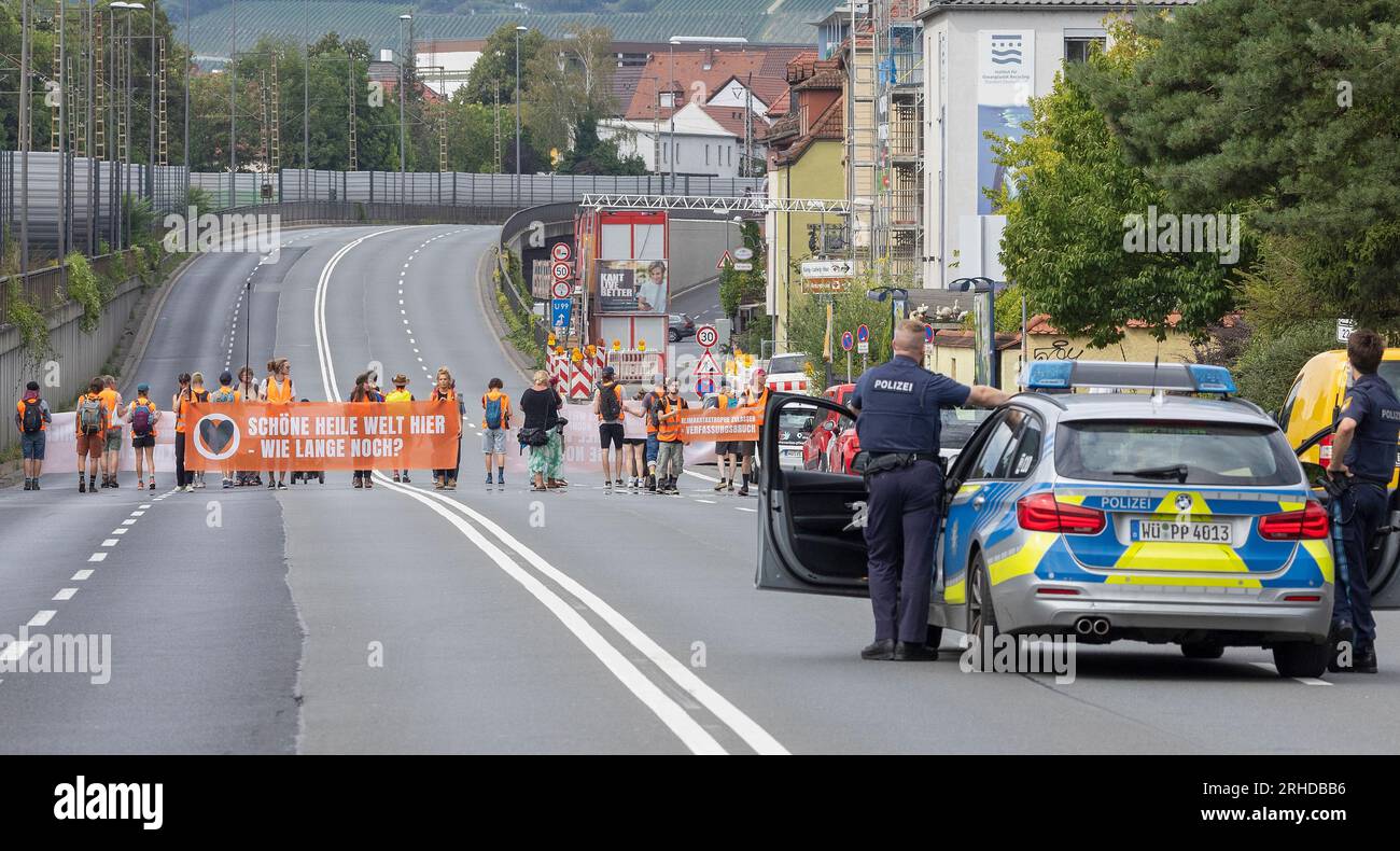 15 août 2023, Bavière, Würzburg : des militants du mouvement climatique de dernière génération bloquent la route fédérale B19. La police a arrêté 43 personnes lors d'un rassemblement de la dernière génération à Würzburg. Lors d'un dernier rassemblement du mouvement pour le climat mardi soir, environ 20 participants auraient bloqué le B19 à plusieurs endroits, a déclaré la police. Selon le rapport, le groupe n ' a pas déblayé la zone même après plusieurs demandes des forces d ' urgence, raison pour laquelle la police a mis fin au rassemblement. Photo : Heiko Becker/HMB Media/dpa Banque D'Images