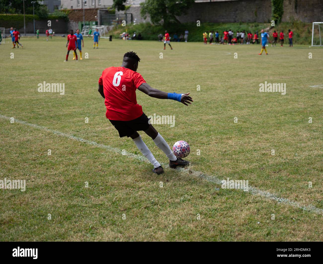 Un footballeur qui donne un coup de pied à un ballon pendant un match. Banque D'Images