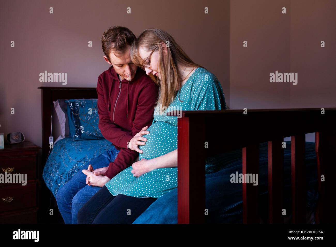 Jeune couple chrétien priant ensemble dans la chambre pour bébé à naître Banque D'Images