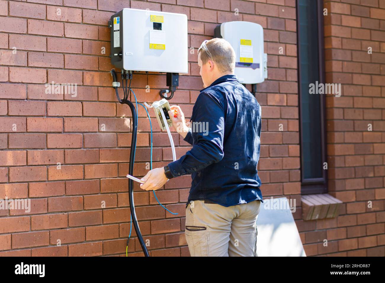 Electrical tradie travaillant comme électricien faisant une installation d'énergie solaire sur la maison Banque D'Images