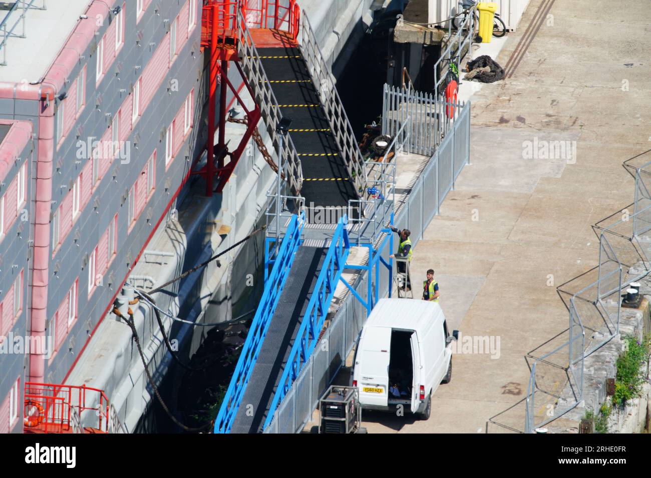 RETRANSMISSION DES INFORMATIONS DE LÉGENDE MODIFIÉES personnes embarquant sur la barge d'hébergement Bibby Stockholm au port de Portland dans le Dorset. Des demandeurs d'asile ont été placés à bord de la barge lundi la semaine dernière, mais ont été retirés vendredi après que des tests aient révélé la légionelle - la bactérie qui peut causer la maladie des légionnaires potentiellement mortelle. Date de la photo : mercredi 16 août 2023. Banque D'Images