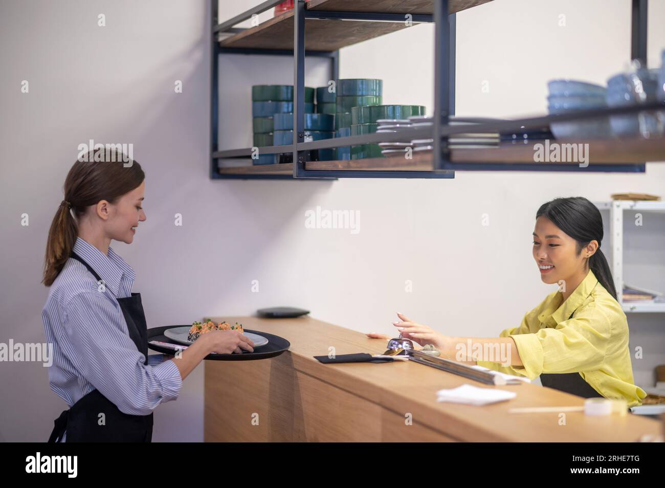 Serveuse prenant la commande du comptoir au café Banque D'Images