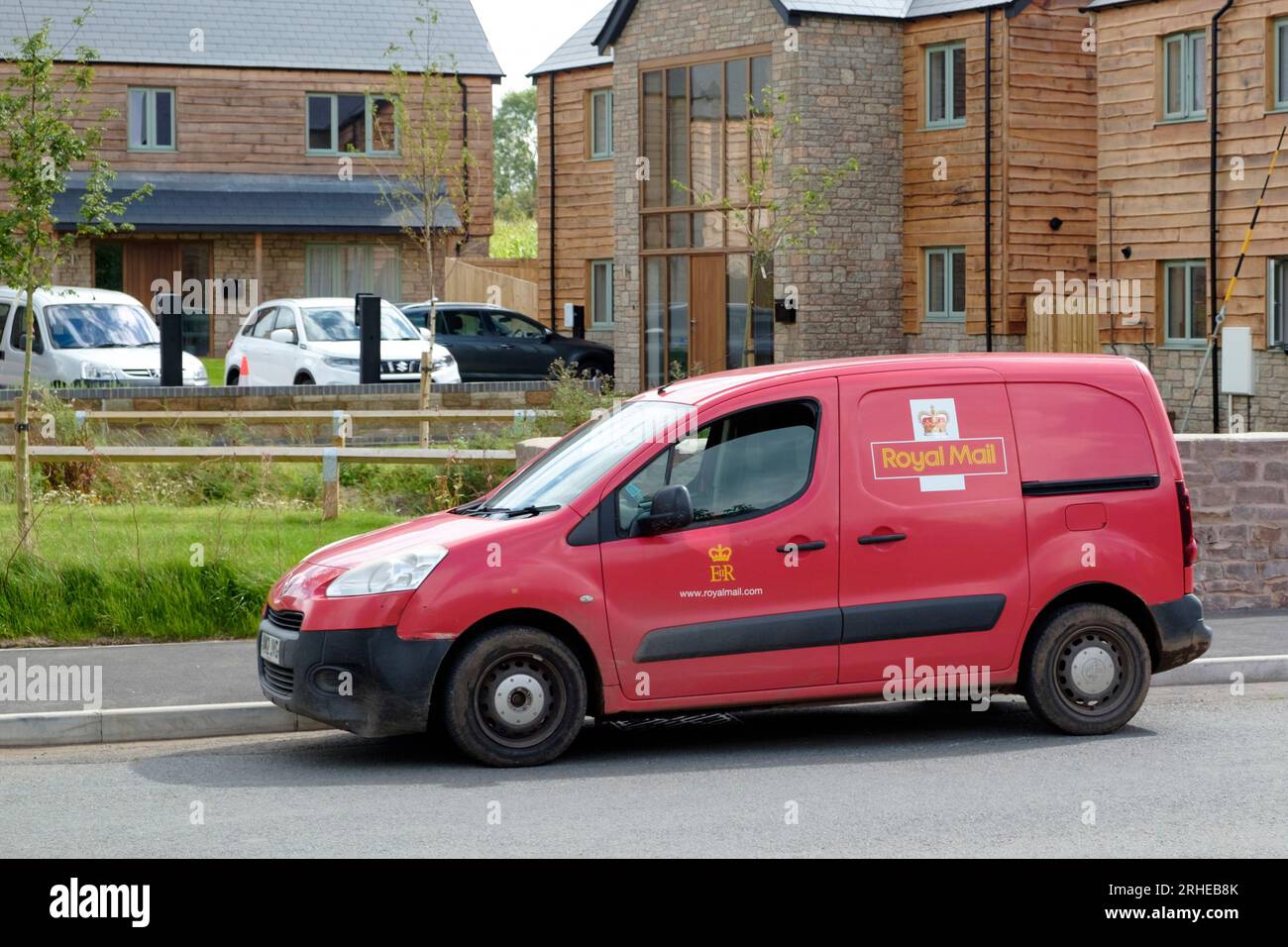 Village d'Alvington dans la forêt de Dean Gloucestershire UK. Fourgon de bureau de poste rouge à l'extérieur du nouveau logement. Banque D'Images