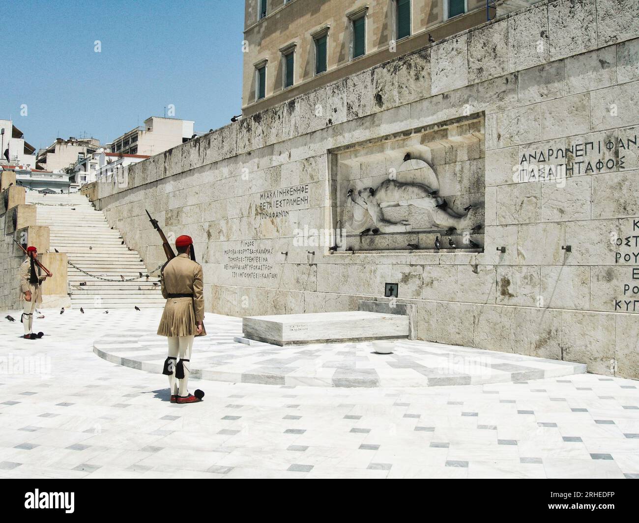Athènes, Grèce - 2005-08-10 - Un adulte de sexe masculin se tient debout sur la défensive, tenant une arme contre un mur de pierre solide en arrière-plan Banque D'Images