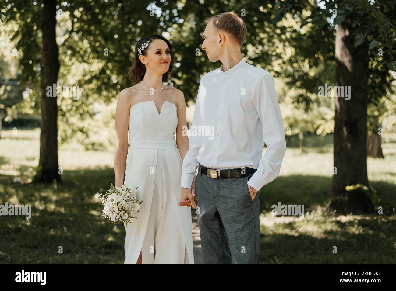 Beau couple de mariage rire et embrasser sur le fond de parc vert. Photo de haute qualité Banque D'Images Beau couple de mariage rire et embrasser sur le fond de parc vert. Photo de haute qualité Banque D'Images