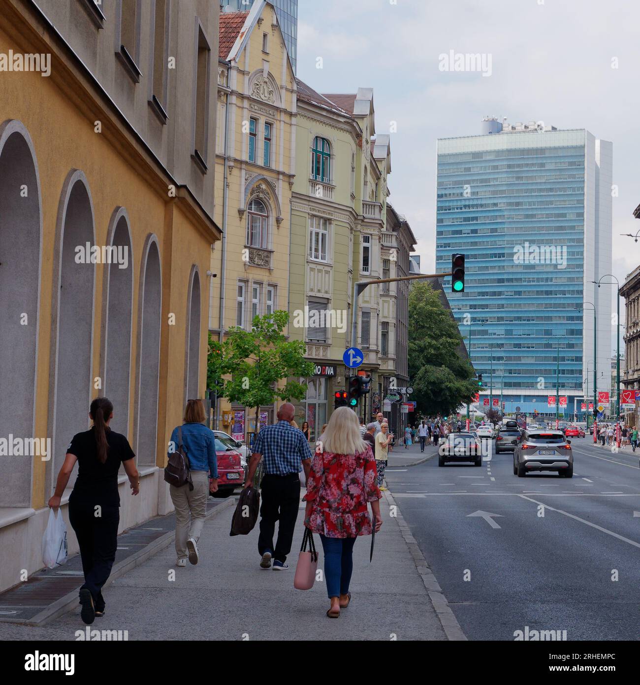 Rue avec piétons et circulation dans la partie moderne de la ville de Sarajevo avec un immeuble derrière, Bosnie-Herzégovine, 16 août 2023. Banque D'Images