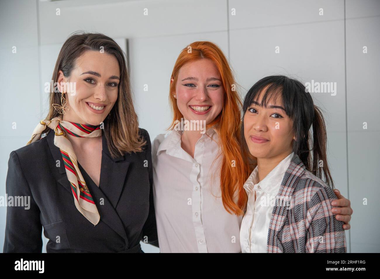Trois jeunes femmes d'affaires souriant ensemble dans le bureau, groupe multiethnique Banque D'Images