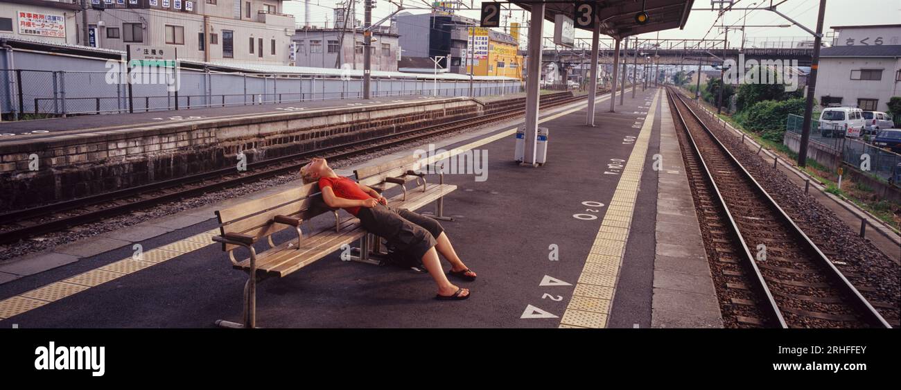 Panorama de voyageur épuisé sur la plate-forme de train à Nara, au Japon pendant la vague de chaleur. (modèle validé) Banque D'Images