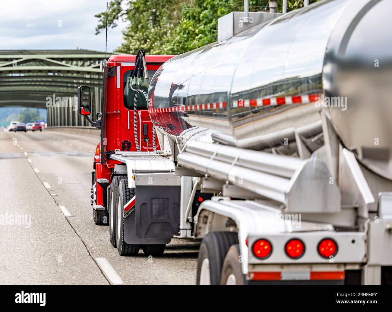 Cabine basse rouge professionnelle standard pour un meilleur aérodynamisme du tracteur de semi-camion lourd de grande plate-forme transportant des marchandises commerciales dans un réservoir brillant Banque D'Images