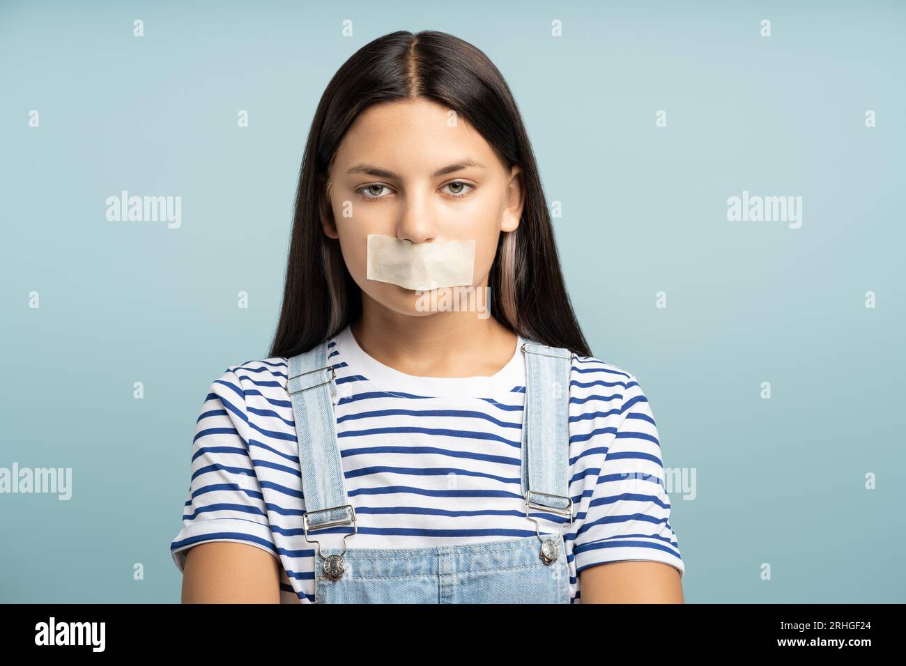 Adolescente triste avec la bouche tapée, faisant le silence, la censure. Restriction de la liberté d'expression. Banque D'Images