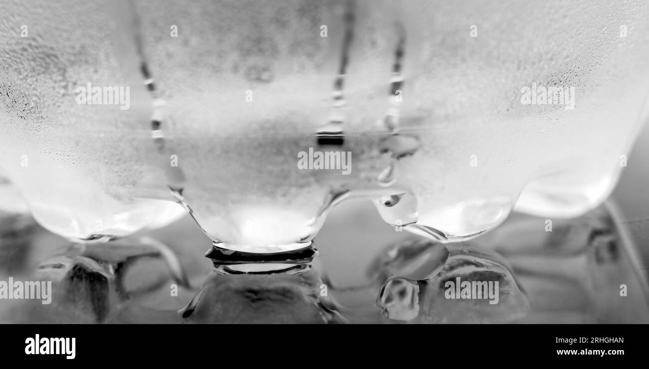 Gouttelettes d'eau sur fond gris. Fond de bouteille en plastique transparent Banque D'Images