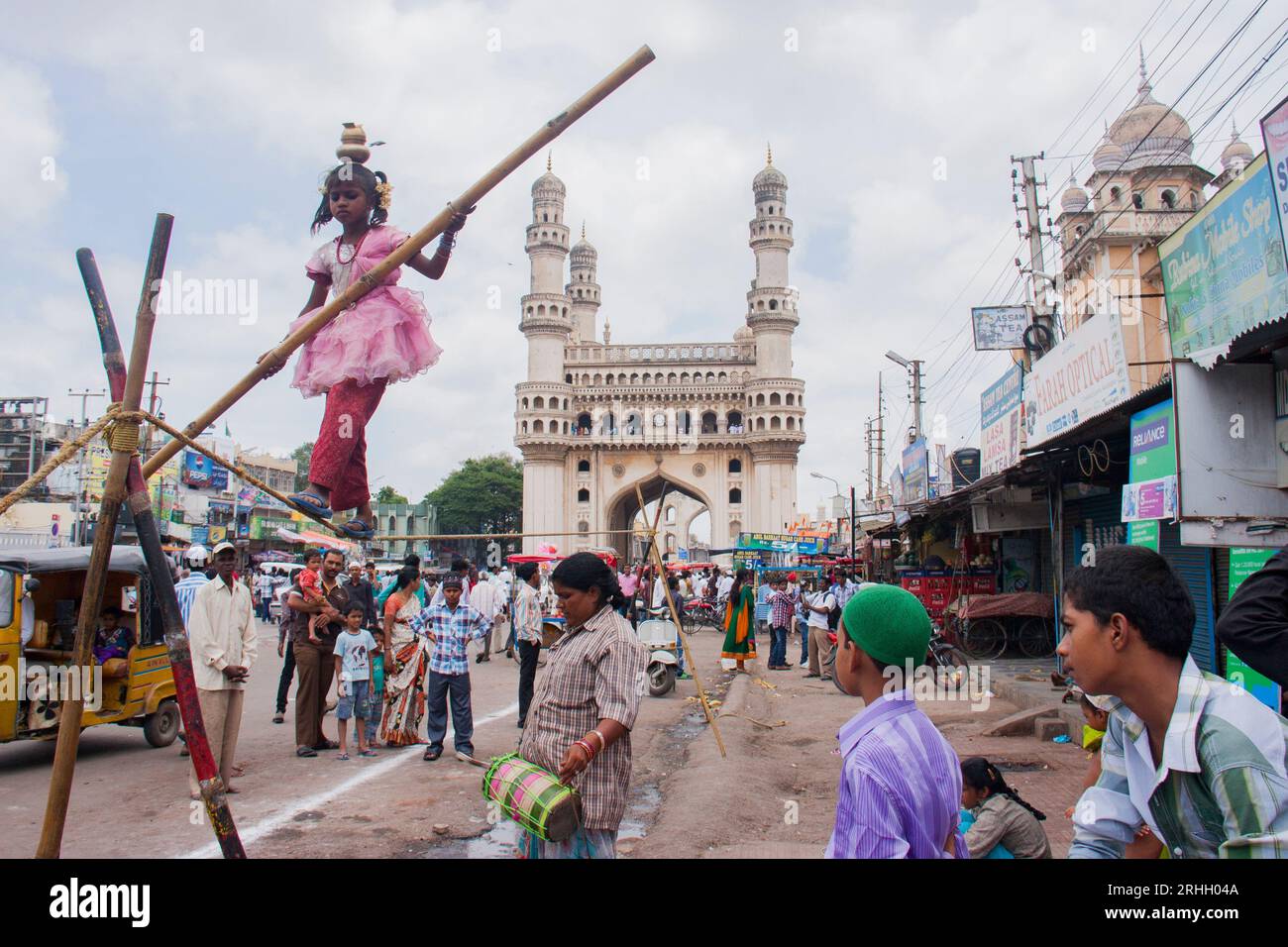 Certains parents utilisent leurs enfants pour mendier leurs besoins. Surtout dans la ville d'Hyderabad, les enfants mendient sur les routes pendant les foires et les festivals. Pendant le festival Ganesh immersion à King Koti, une mère couvrit son fils de peinture aluminium pour mendier sous la pluie. Hyderabad, Inde. Banque D'Images