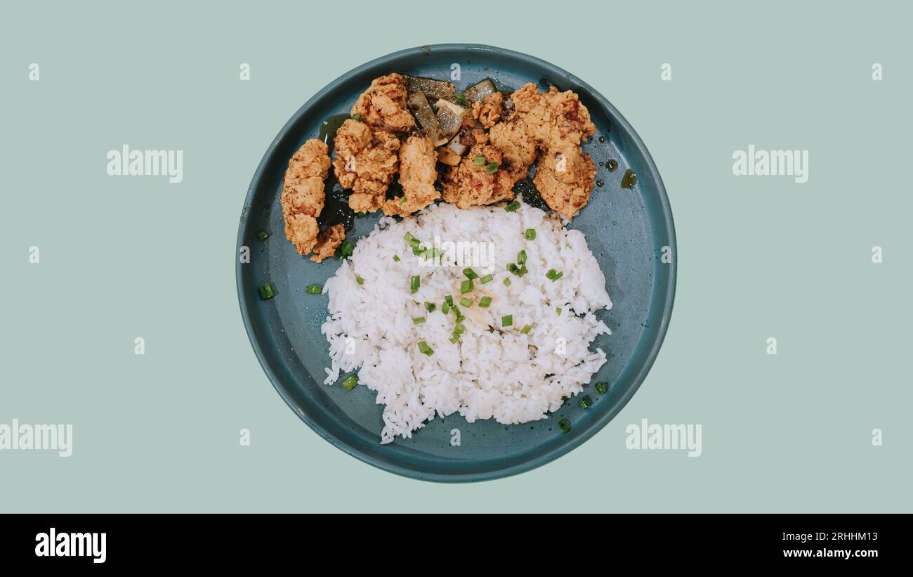 Plat Lay ou vue de dessus d'une assiette de poulet frit avec du riz sur fond pastel vert sauge isolé Banque D'Images