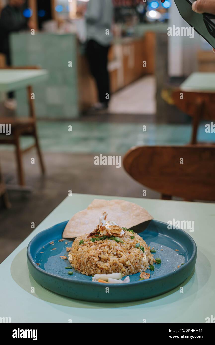 Portrait ou photo de mise au point verticale et sélective d'une assiette de Nasi Goreng ou de riz frit avec craquelin, carottes et concombre Banque D'Images