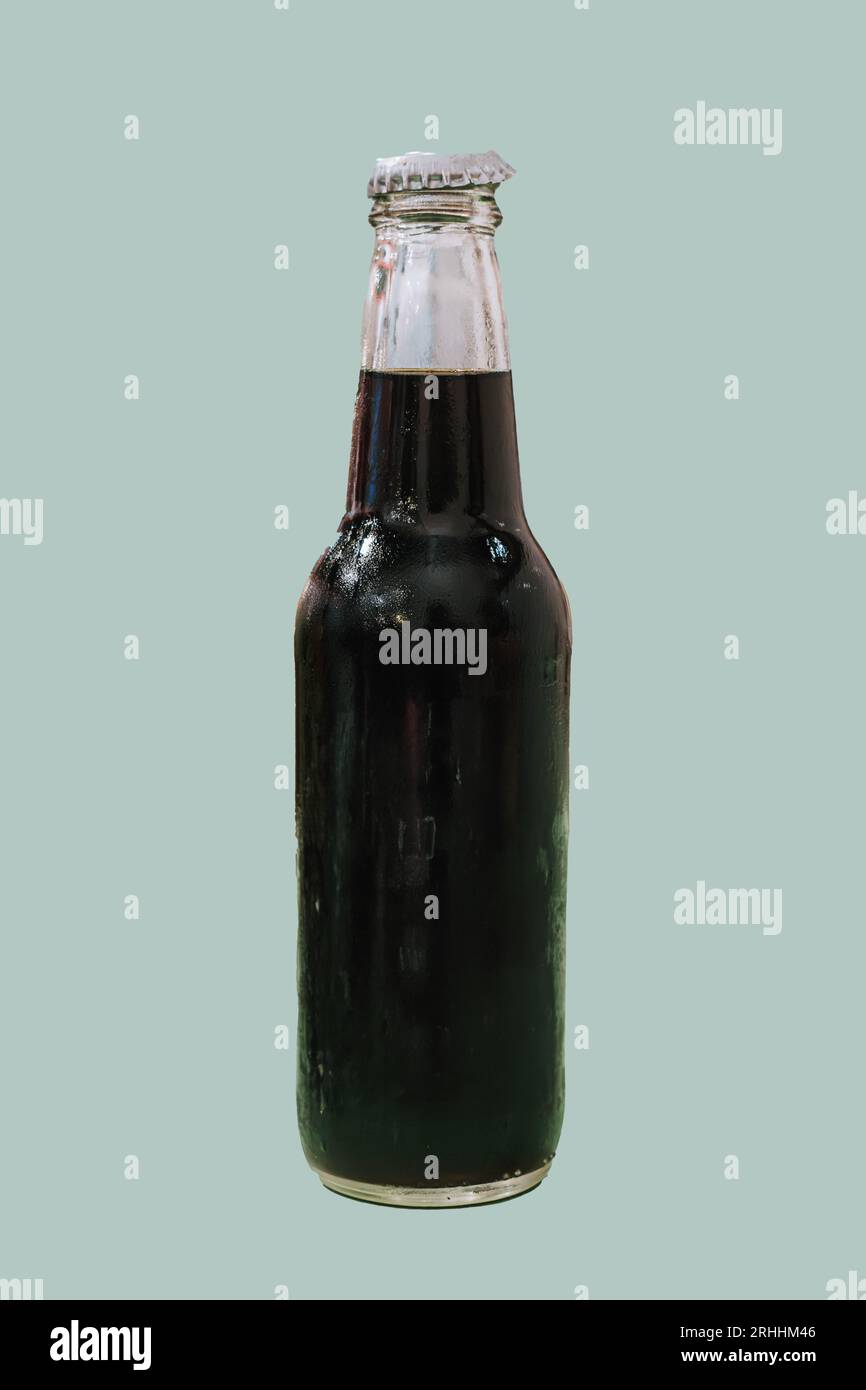 Portrait ou photo verticale et mise au point sélective d'une bouteille de bière sur fond pastel vert sauge isolé Banque D'Images