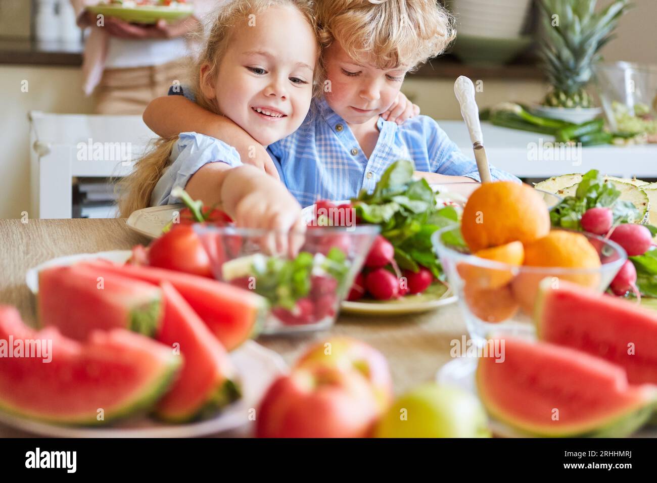 Deux frères et sœurs heureux profitant d'un repas sain avec des fruits frais et des produits Banque D'Images Deux frères et sœurs heureux profitant d'un repas sain avec des fruits frais et des produits Banque D'Images