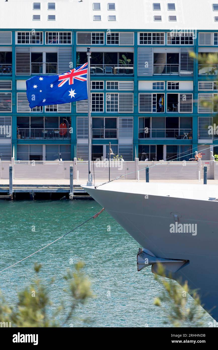 Le drapeau national australien volant à la proue du HMAS Arunta amarré à Garden Island à Sydney, en Australie Banque D'Images