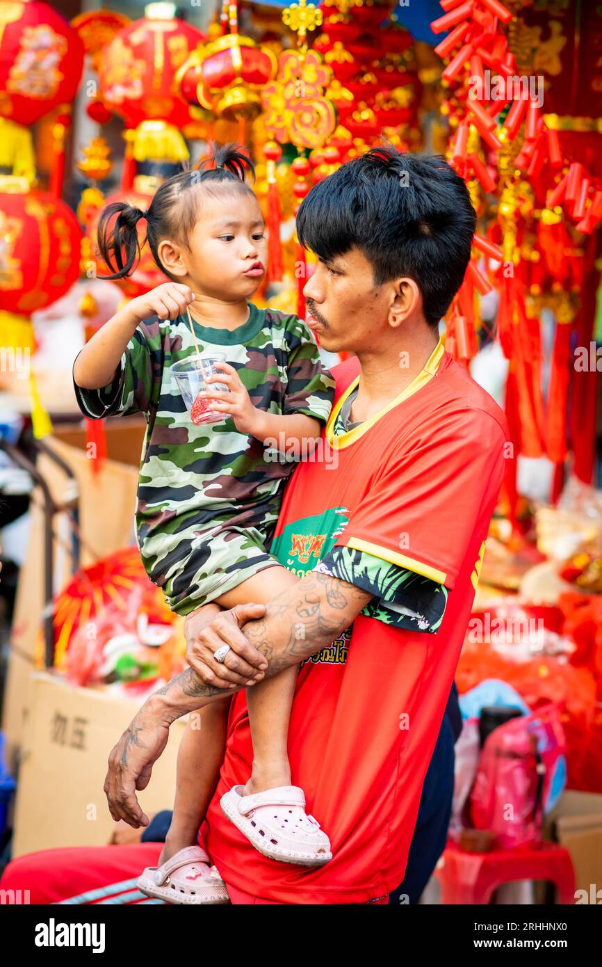 Un fier jeune papa thaïlandais joue avec sa belle petite fille à China Town, Bangkok, Thaïlande. Banque D'Images