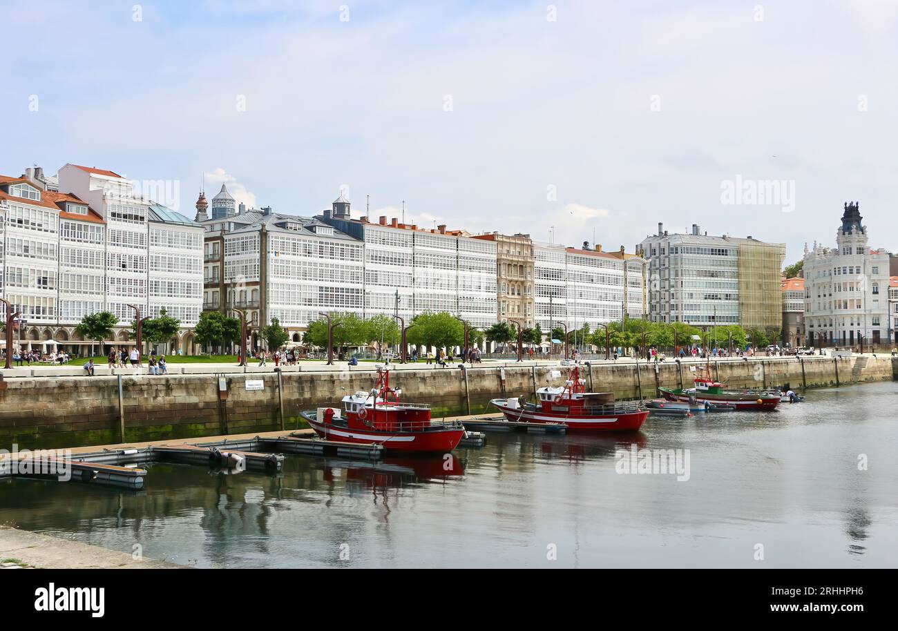 Bateaux de pêche amarrés dans le port avec des bâtiments le long de l'Avenida Marina A Coruña Galice Espagne Banque D'Images
