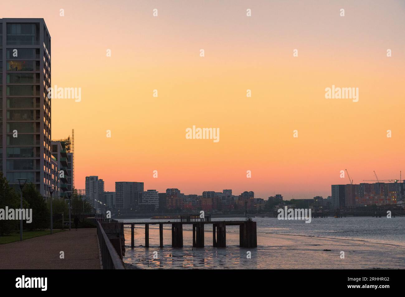 Beau coucher de soleil sur la rivière avec skyline de la ville et des bâtiments modernes le long de la promenade du front de mer. Woolwich, sud-est de Londres. Banque D'Images