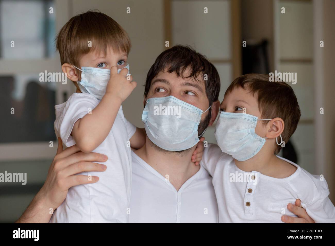 Père et fils en masques médicaux à la maison. Image avec mise au point sélective. Photo de haute qualité Banque D'Images