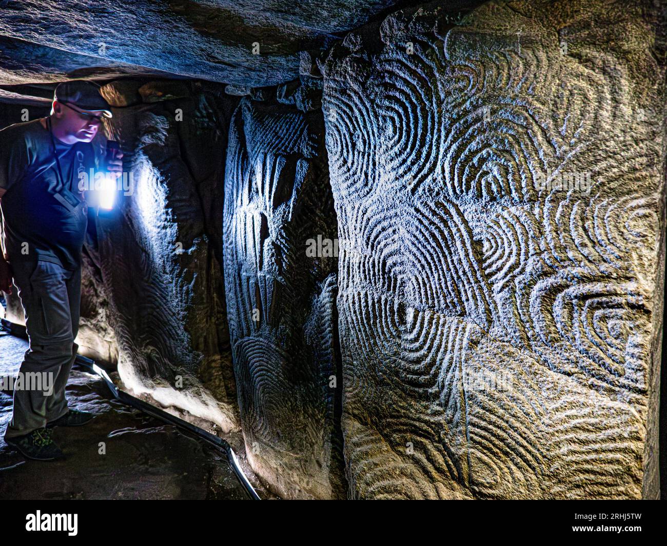 Visite guidée aux flambeaux GAVRINIS GUIDE de sculptures en pierre de l'intérieur de la texture, la France Bretagne cairn préhistorique, dolmen, tombe en pierre sèche, avec le célèbre et symbolique de l'âge de pierre mystérieux sculptures. Un des exemples les plus remarquables de la première apparition de l'architecture dans le monde occidental. Cairn de Gavrinis Cale de Penn-Lannic Sagemor larmor baden, Bretagne France (Megalithes du Morbihan) Banque D'Images