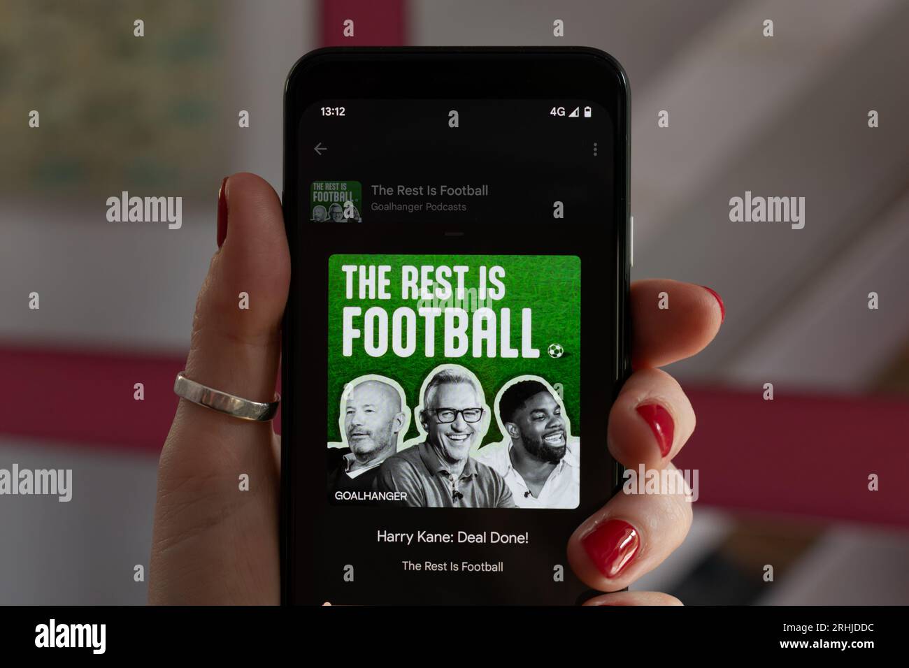 He Rest is football podcast jouant sur un téléphone mobile Google Pixel 4. Main de femme avec des ongles rouges. Harry Kane avec Gary Linaker Banque D'Images