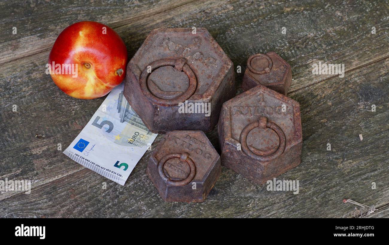 Vieux poids rouillés, une nectarine, cinq euros. Concept d'inflation. Coût de la vie. Banque D'Images