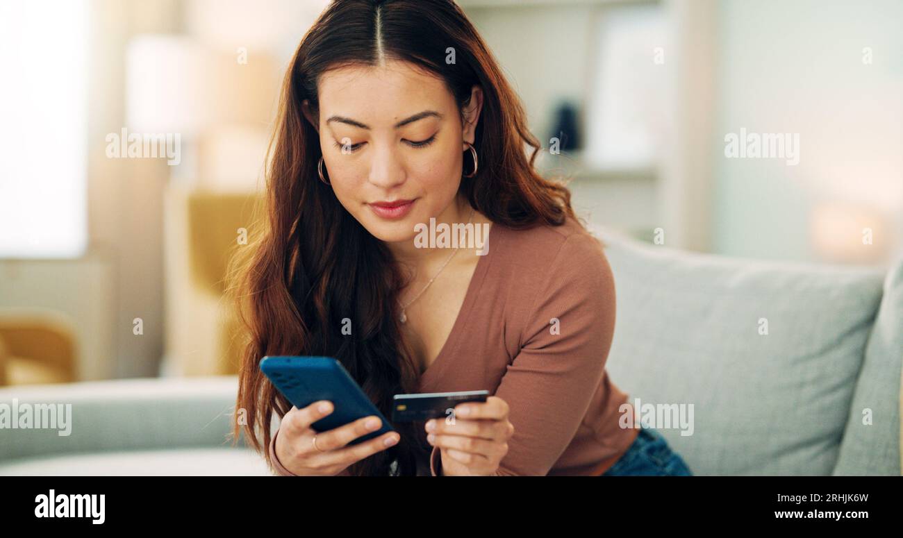 Femme, carte de crédit et téléphone pour le commerce électronique, les achats en ligne et l'application de banque Fintech sur la maison ou le canapé de salon à la maison. Souriez, heureux et détendez le client Banque D'Images