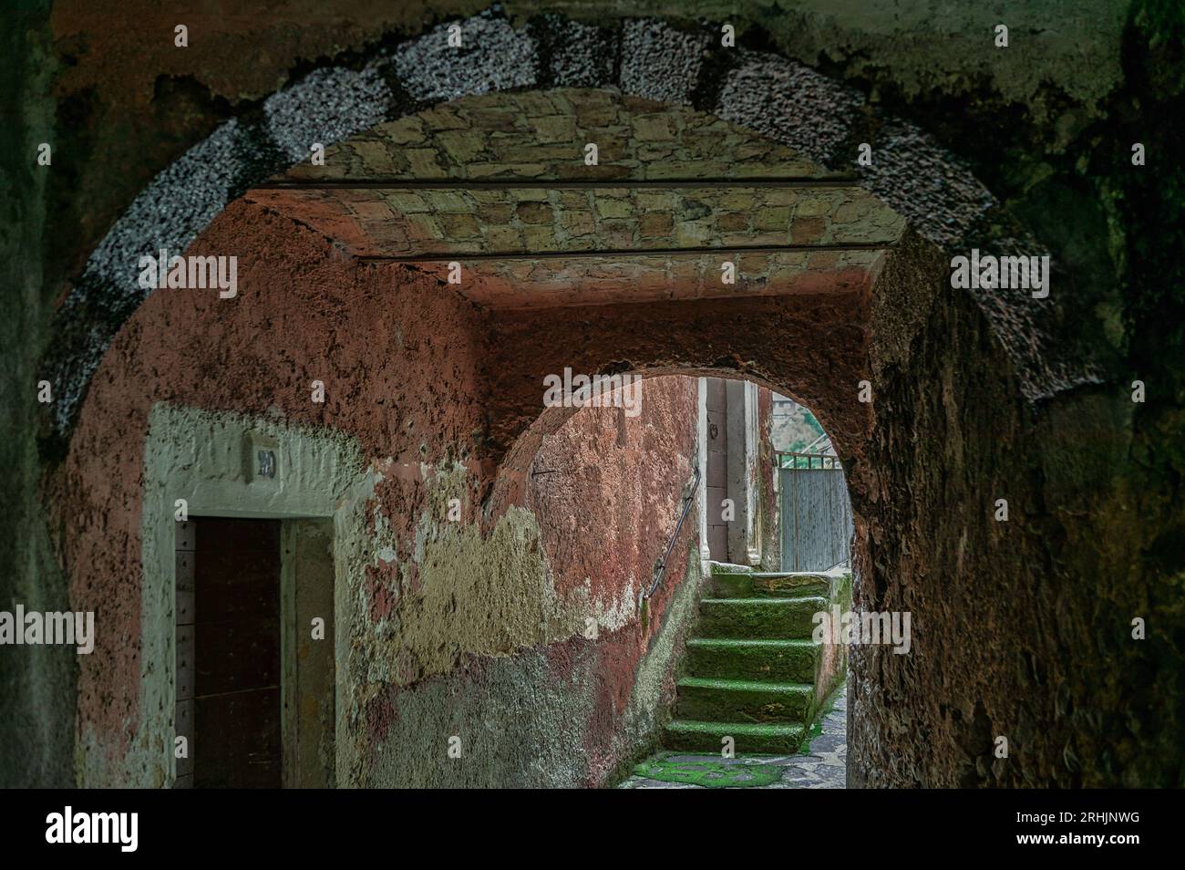 Une maison de couleur rouge, une passerelle couverte et un escalier d'accès à une maison dans le centre historique de Prezza. Prezza, Abruzzes, Italie, Europe Banque D'Images