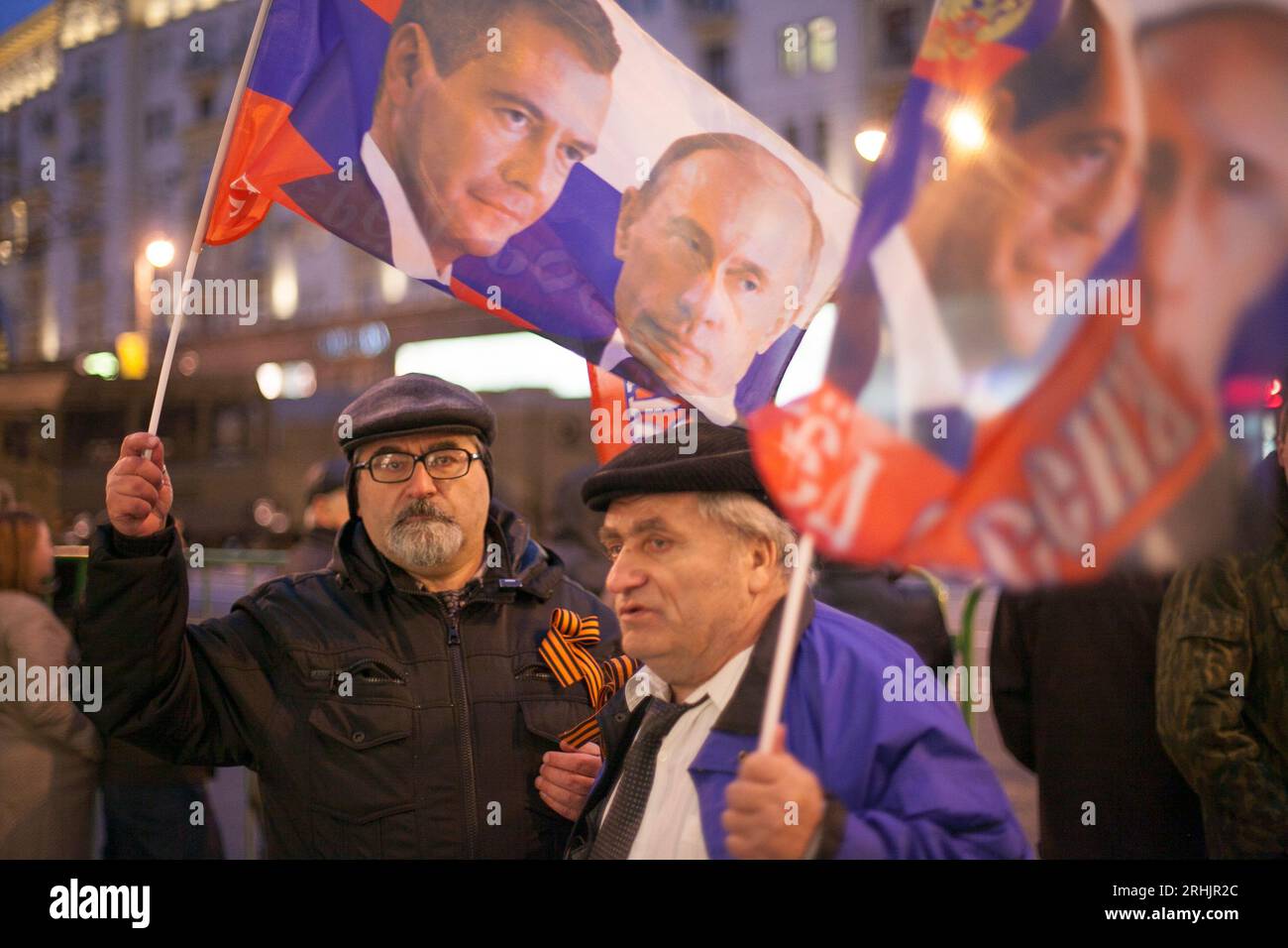 Des hommes tiennent des drapeaux montrant le président russe Vladimir Poutine et Dmitri Medvedev à Moscou, en Russie. Banque D'Images