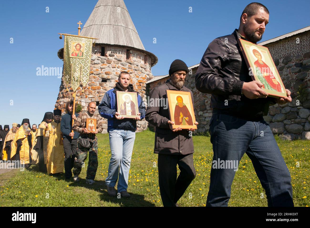 Les hommes portent des icônes à l'extérieur d'une église orthodoxe russe au monastère de Solovetsky dans la mer Blanche de Russie. Banque D'Images
