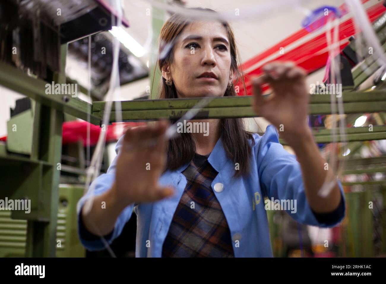 Une femme travaille dans un métier à coton à Kokand, en Ouzbékistan. Banque D'Images