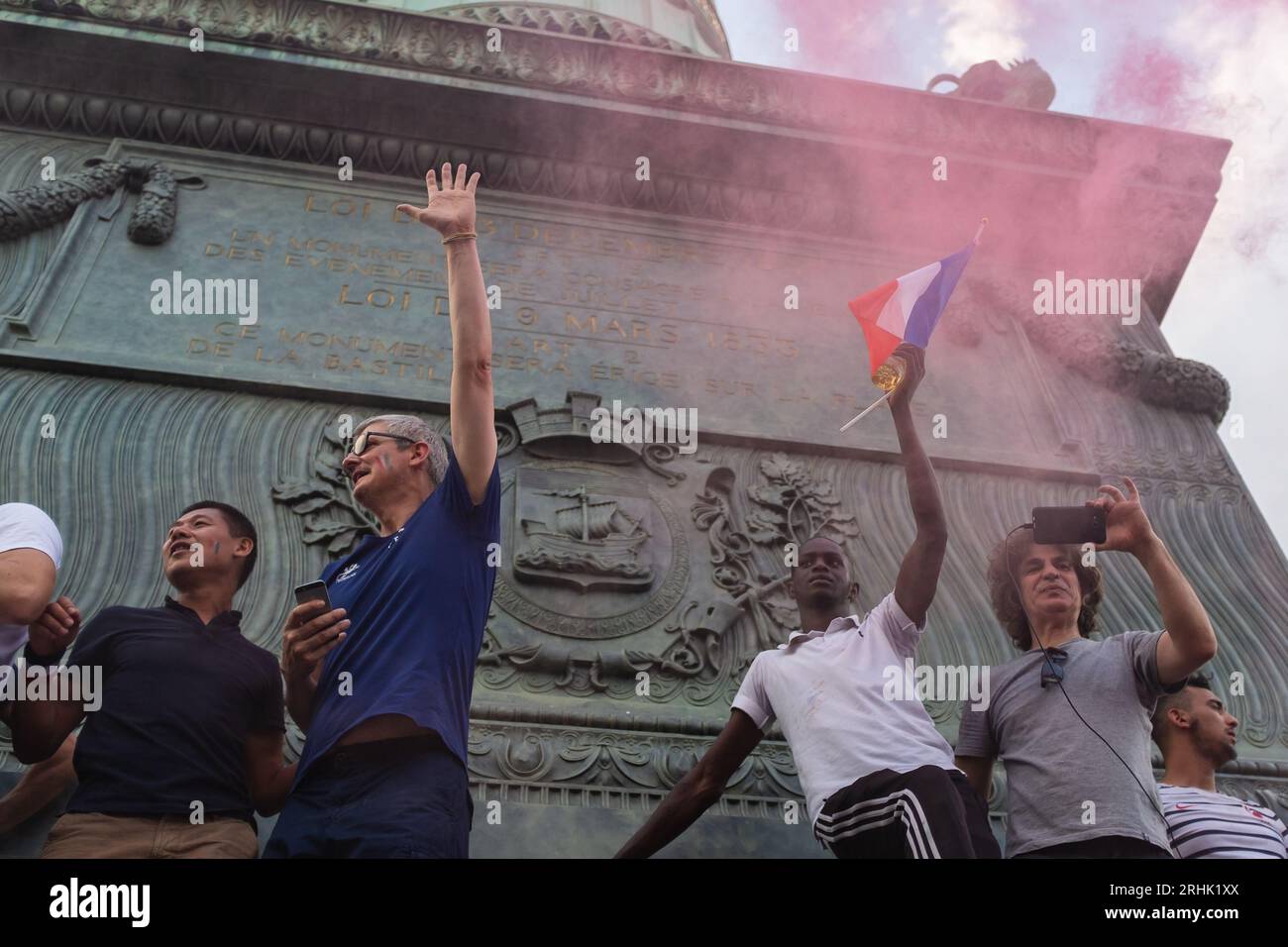 Paris, France, 2018. Hommes debout sur la colonne de juillet dans un nuage de grenade fumée rose faisant signe à la foule pour célébrer la coupe du monde de football de France Banque D'Images