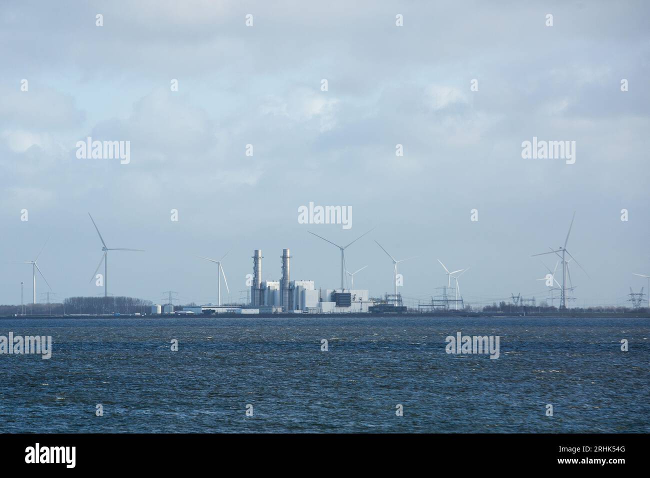 Lelystad, pays-Bas. 11 janvier 2023. Les éoliennes et la centrale à gaz Maxima-centrale exploitées par GDF SUEZ Energie Nederland avec une puissance totale de 880 MW sont visibles depuis le Houtribdijk, barrage de 27 kilomètres de long qui relie les villes de Lelystad et Enkhuizen aux pays-Bas. Le long du barrage, entre les lacs pittoresques Markermeer et Ijsselmeer passe la route N307. Crédit : SOPA Images Limited/Alamy Live News Banque D'Images