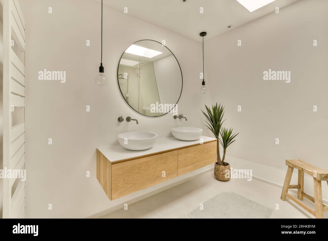 une salle de bain avec deux lavabos et un miroir sur le mur à côté est une plante dans un tabouret en bois Banque D'Images