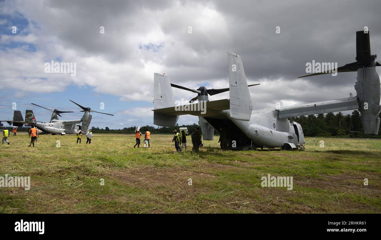 Buka, Papouasie-Nouvelle-Guinée. 12 août 2023. Les villageois et la police néo-zélandaise chargent des fournitures d’urgence sur un avion US Marine MV-22B Osprey pour les distribuer dans les zones reculées après les éruptions du volcan Bagana, le 12 août 2023 à Buka, île de Bougainville, Papouasie-Nouvelle-Guinée. Crédit : Caporal Abigail Godinez/U.S. Marines/Alamy Live News Banque D'Images