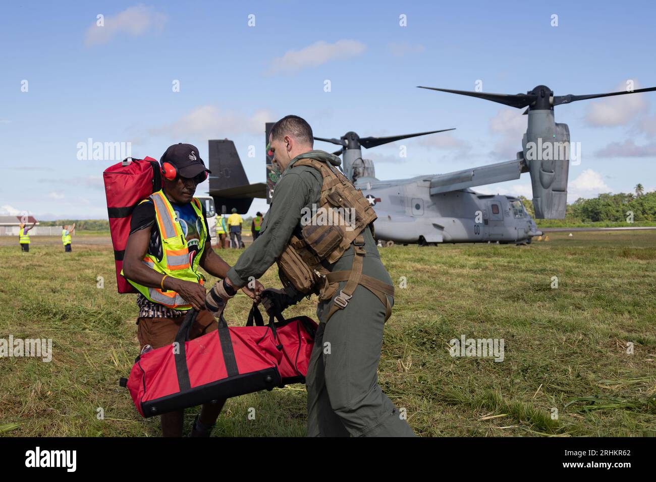 Buka, Papouasie-Nouvelle-Guinée. 12 août 2023. Un travailleur humanitaire local remet des fournitures d'urgence du corps des Marines américain, le major Joshua Culver, à charger sur un avion MV-22B Osprey des Marines américaines pour les distribuer dans les zones reculées après les éruptions du volcan du mont Bagana, le 12 août 2023 à Buka, île de Bougainville, Papouasie-Nouvelle-Guinée. Crédit : Caporal Abigail Godinez/U.S. Marines/Alamy Live News Banque D'Images