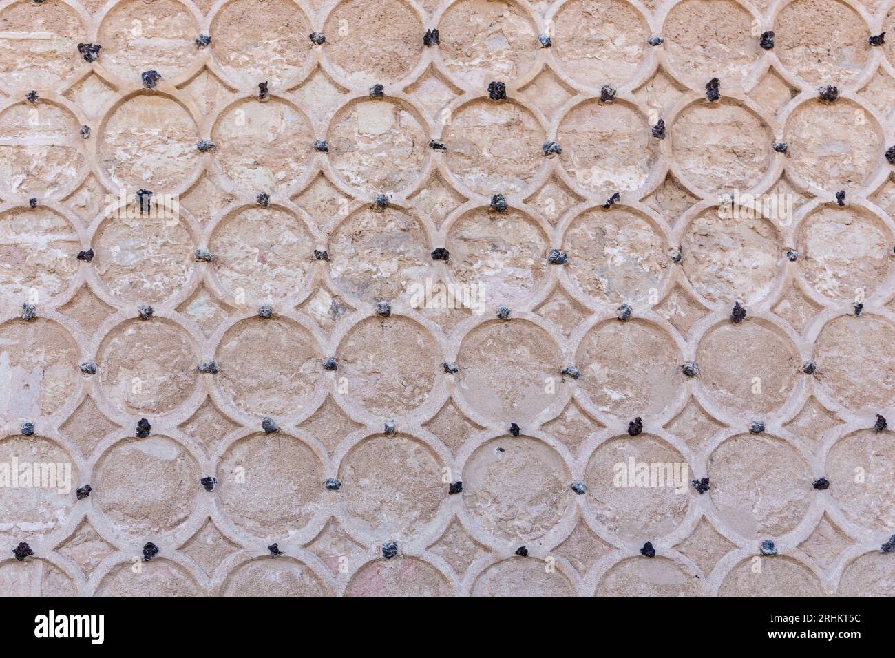 Façade ornementale en pierre de l'Alcazar de Ségovie, Espagne. Ornements islamiques avec motifs circulaires de sgraffites, cercles sculptés sur mur de pierre. Banque D'Images