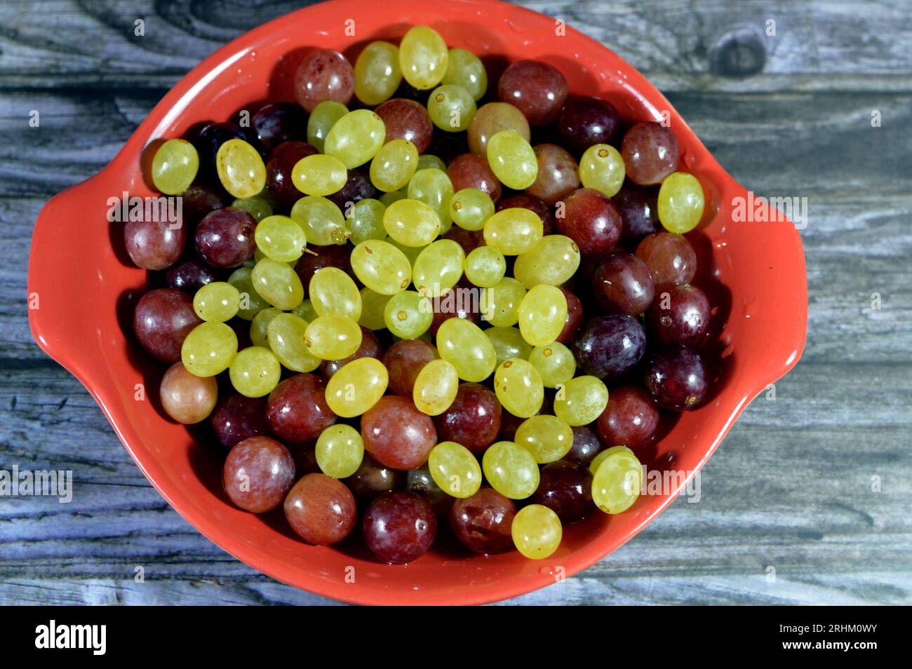 Vert et rouge raisins frais, un fruit, botaniquement une baie des vignes ligneuses à feuilles caduques du genre Vitis. Les raisins sont un non-climatérique Banque D'Images