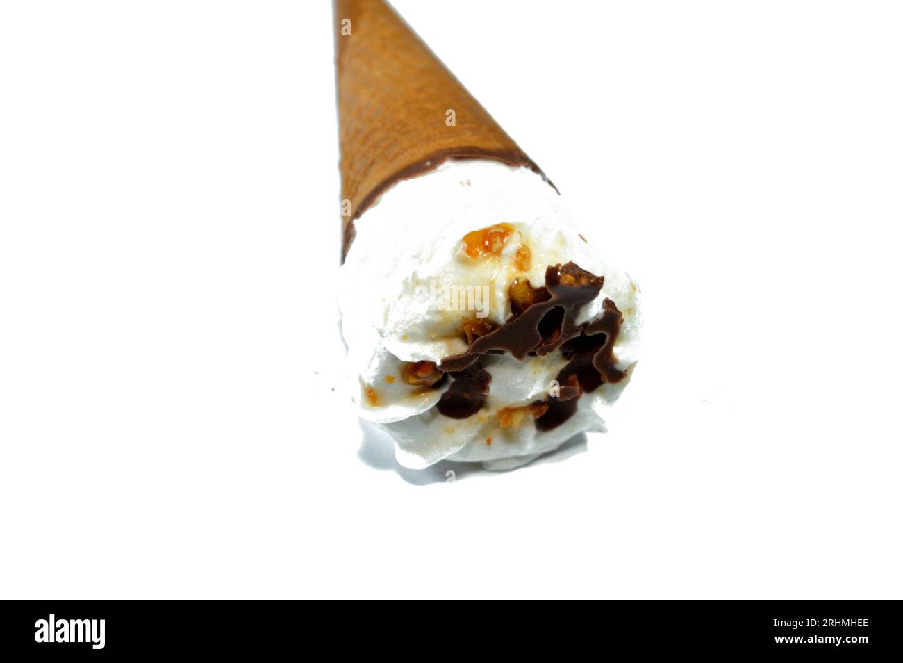 Cône de vanille de crème glacée avec garniture de morceaux de pépites de chocolat, noix et caramel dans une galette croustillante cônes, foyer sélectif de la fonte de la crème glacée froide twi Banque D'Images